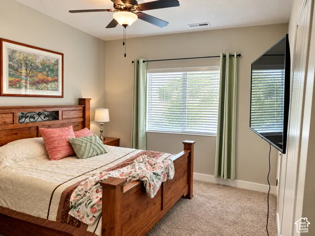 Neutral-toned room featuring a central ceiling fan with an integrated light fixture, horizontal window blinds, and carpeted flooring