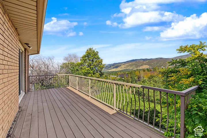 Expansive outdoor deck with composite decking and decorative metal railings, complemented by a brick exterior