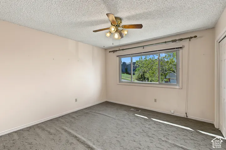 Carpeted room featuring a ceiling fan with integrated lighting, a window with horizontal blinds, and a built-in closet