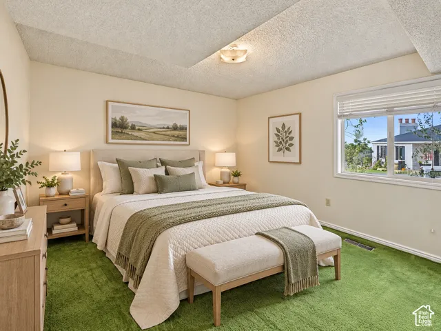 Wall-to-wall green carpeting, neutral wall tones, and a window with horizontal blinds