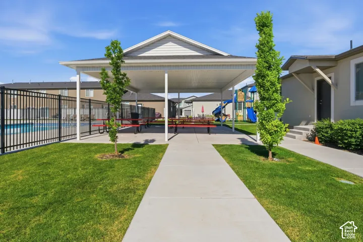 Covered patio area featuring a pitched roof and multiple picnic tables