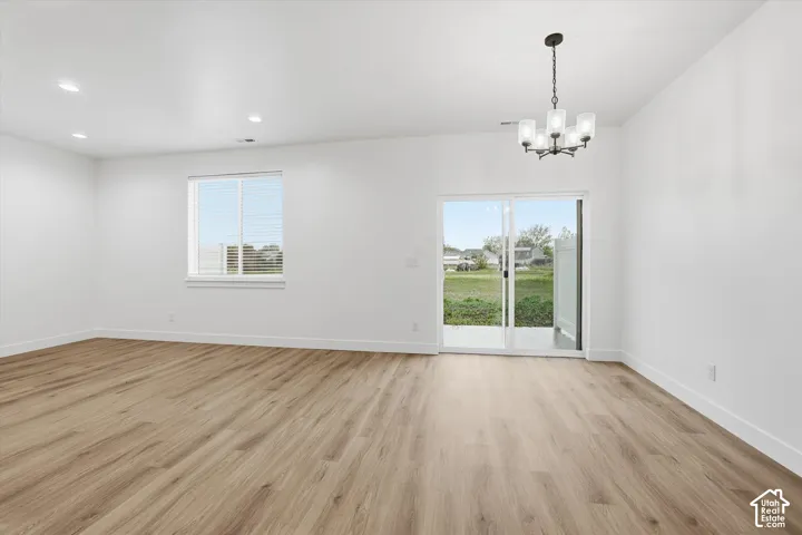 Wood-finish flooring, recessed lighting, and a modern chandelier