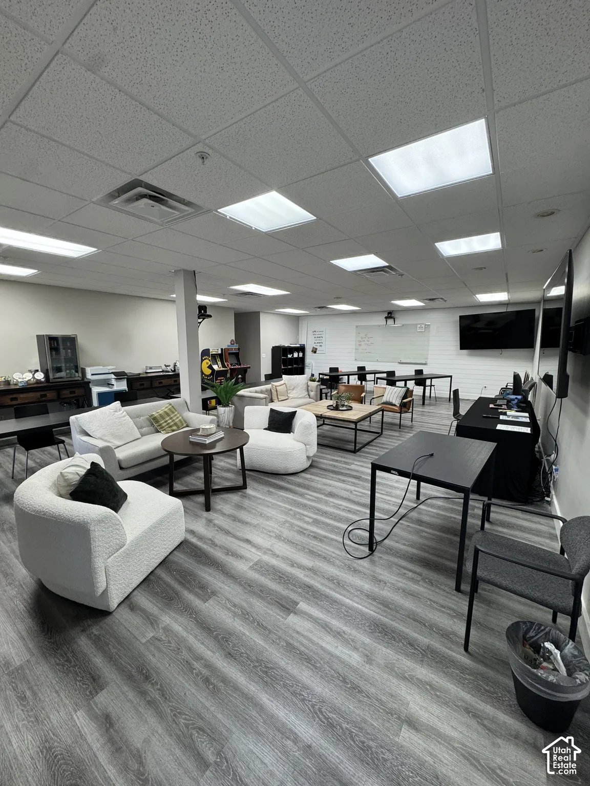 Recessed lighting, wood-finish flooring, drop ceiling, white walls, and built-in wall-mounted displays