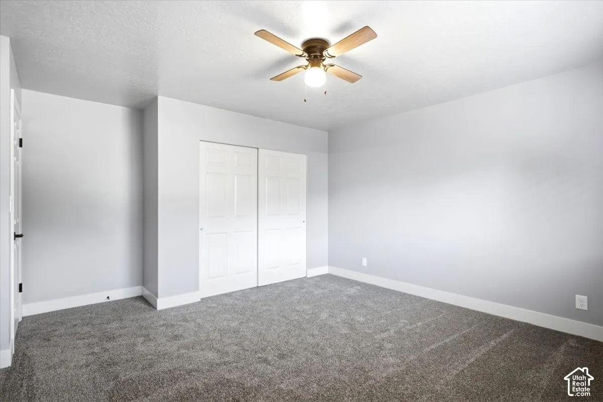 Neutral gray wall finishes, textured ceiling, and gray carpet