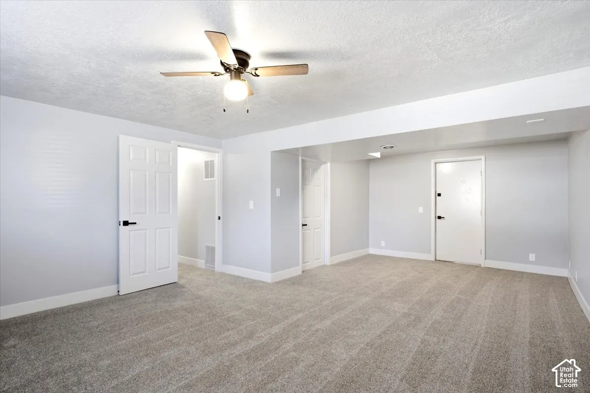 Expansive room featuring plush carpeting, a ceiling fan with integrated lighting, recessed lighting, and multiple paneled doors