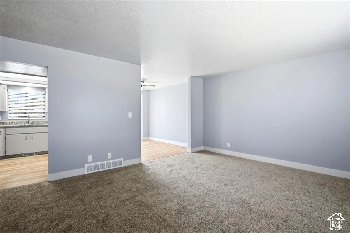 Spacious living area with new carpeting and neutral wall tones