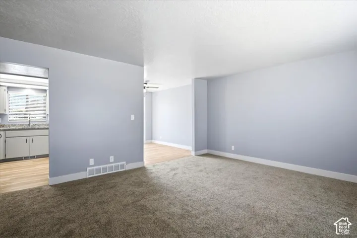 Spacious living area with new carpeting and neutral wall tones