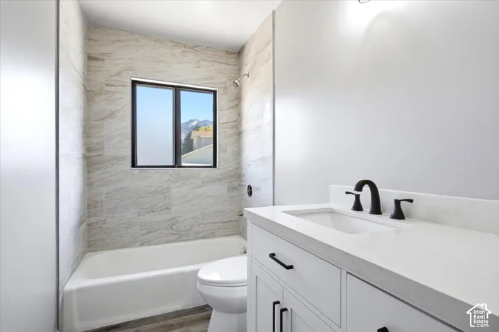 White vanity with a solid surface countertop, matte black faucet, and undermount sink