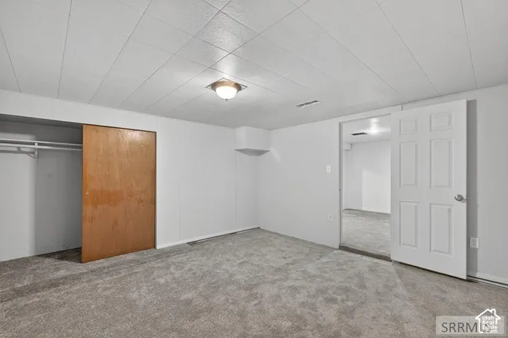 White paneled walls with gray carpet flooring