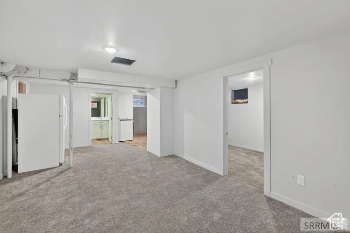 Carpeted flooring, white painted walls, recessed lighting, and a white trim doorway