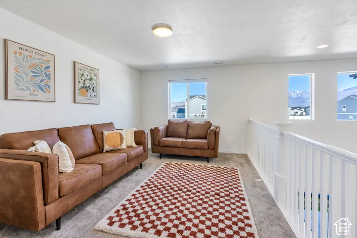 Carpeted flooring, white balustrade, multiple windows, recessed lighting, and a flush mount ceiling light