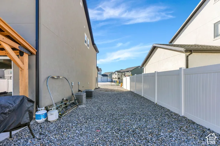 Gravel ground cover with a white privacy fence and stucco exterior