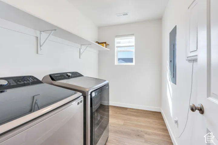 Laundry area featuring wood-finish flooring, a window with blinds, and a built-in shelf