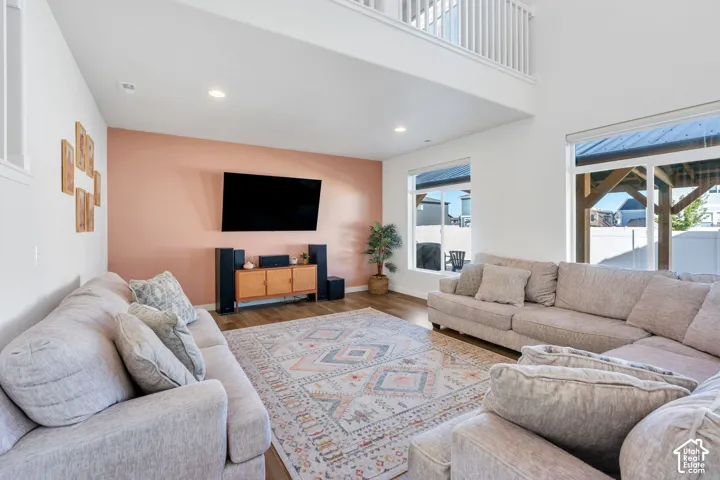 Vaulted ceilings with an open loft, wood-finish flooring, recessed lighting, and large windows