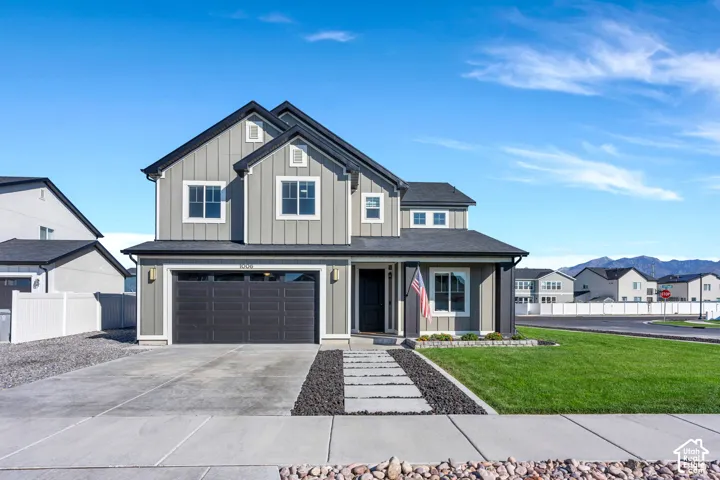 Two-story residence featuring a two-car garage, concrete driveway, and a front walkway with integrated pavers