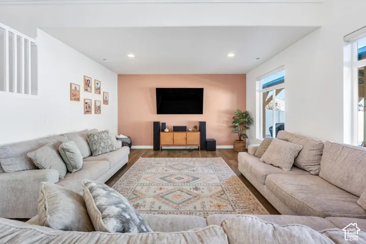 Wood-finish flooring with recessed lighting, large windows, and a built-in media console