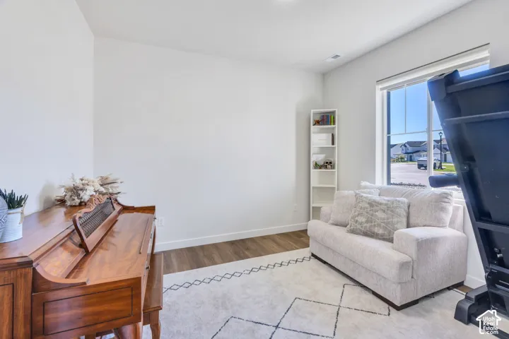 Bright interior space featuring wood-finish flooring, a large window, and recessed lighting