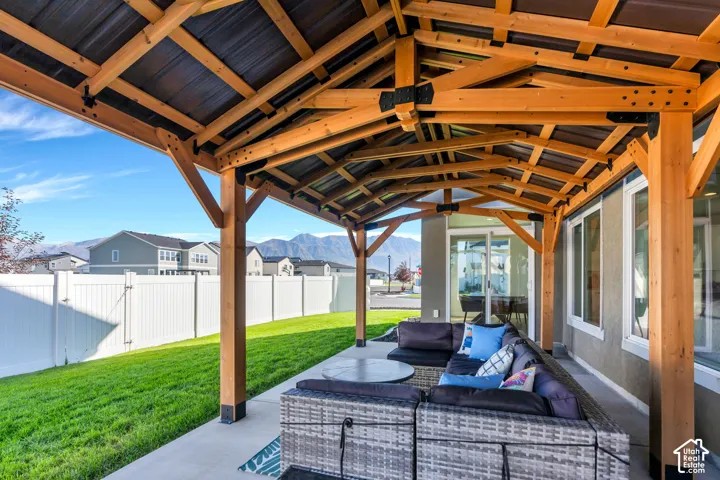 Expansive outdoor patio with a wooden pergola, concrete flooring, and a metal roof