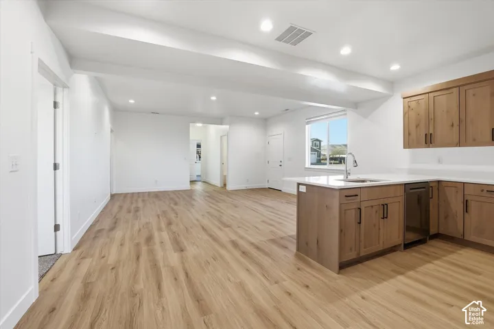 Open-concept living space with wood-finish flooring, recessed lighting, and a white color palette