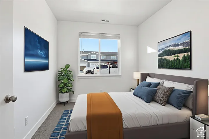 Crisp white walls, neutral carpet flooring, and a large window providing natural illumination