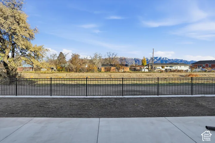 Concrete patio with a black metal fence and distant mountains