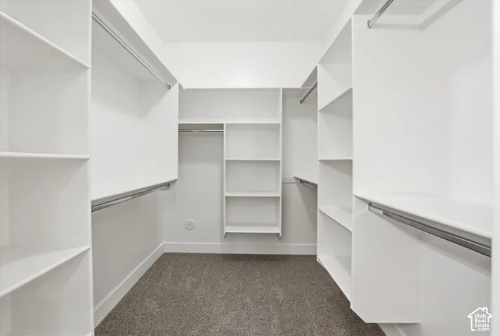 Custom closet system with multiple shelving units and hanging rods
