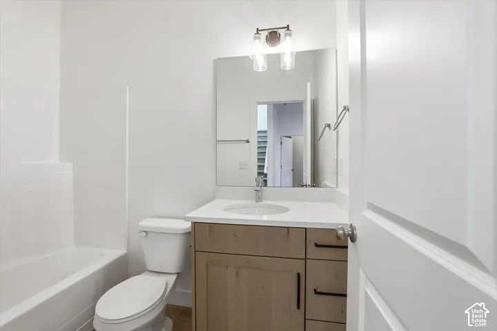 Bathroom featuring a single-sink vanity with wood-finish cabinetry, a white countertop, and a rectangular mirror