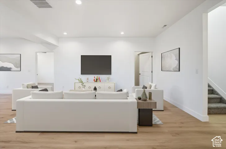 Recessed lighting illuminates wood-finish flooring
