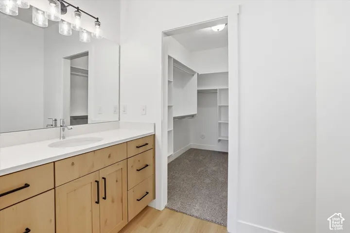 Wood-finish vanity with a white countertop and undermount sink