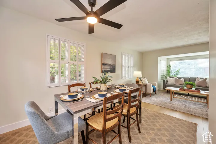 Recessed lighting, wood-finish flooring, white plantation shutters, and a bay window