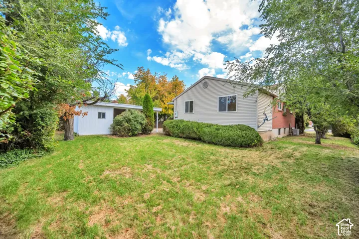 Spacious residential property featuring a siding exterior, pitched roofline, and brick chimney