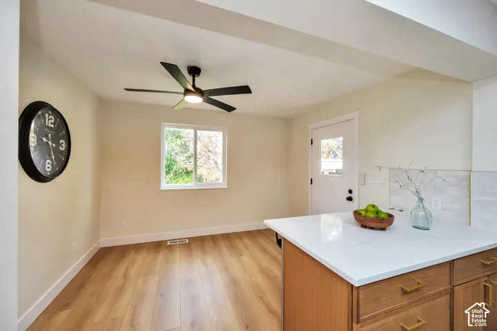 Wood-finish flooring, white walls, and a window with exterior visibility