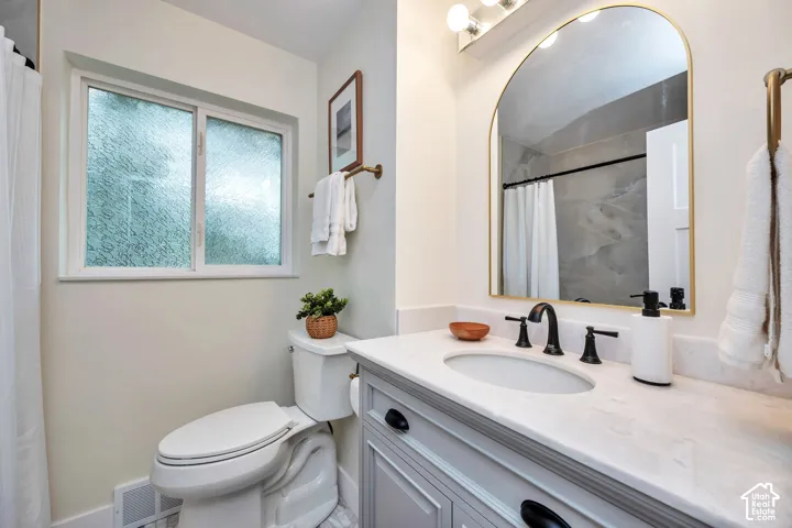 Modern bathroom featuring a floating vanity with white quartz countertop, undermount sink, and matte black faucet hardware