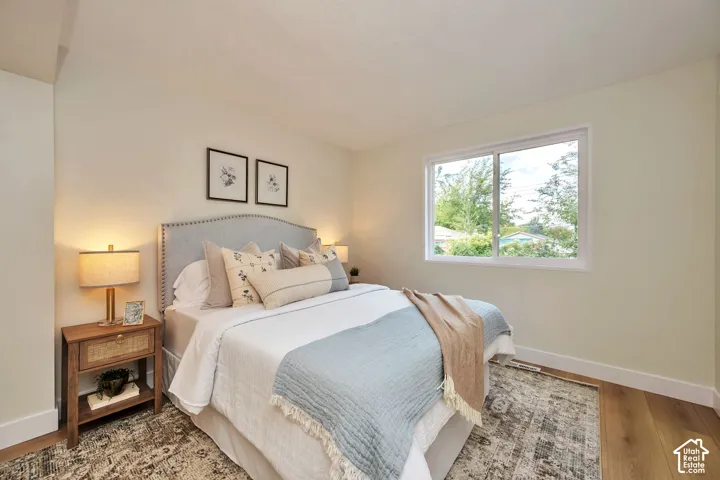 Wood-finish flooring, light neutral wall tones, and a large window with white framing