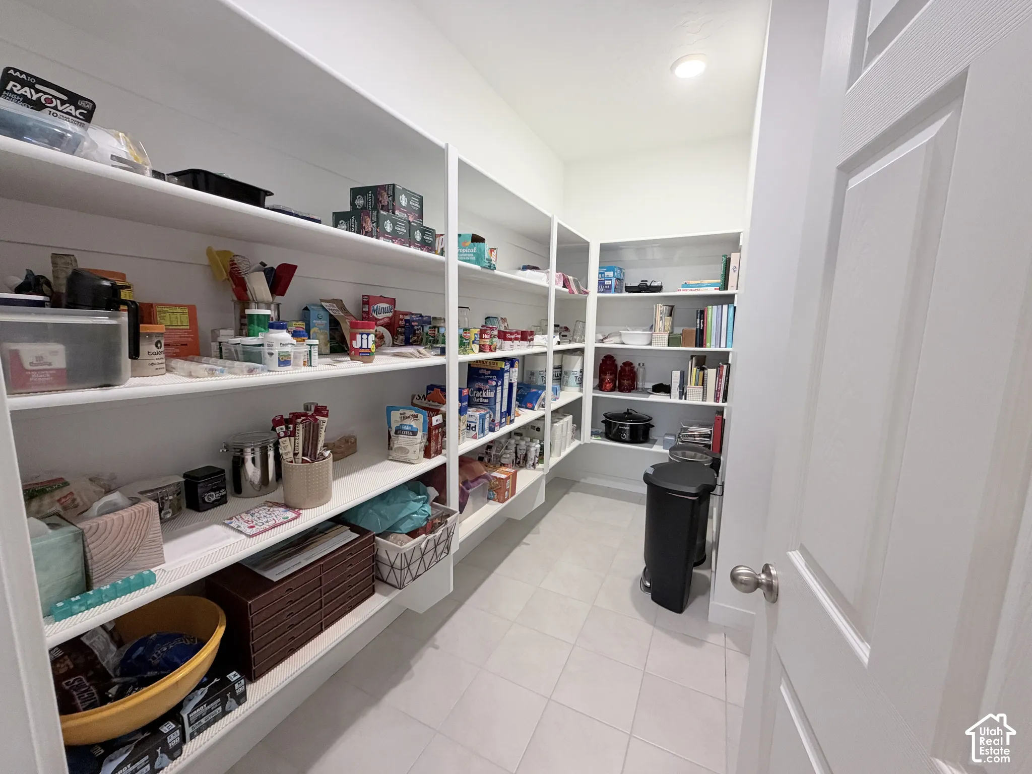 Expansive pantry featuring extensive shelving, white finishes, and recessed lighting