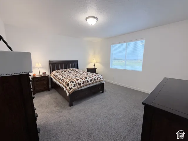 Spacious interior with neutral wall tones, window with horizontal blinds, and wall-to-wall carpeting