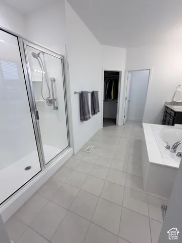 Walk-in shower with clear glass enclosure and chrome fixtures