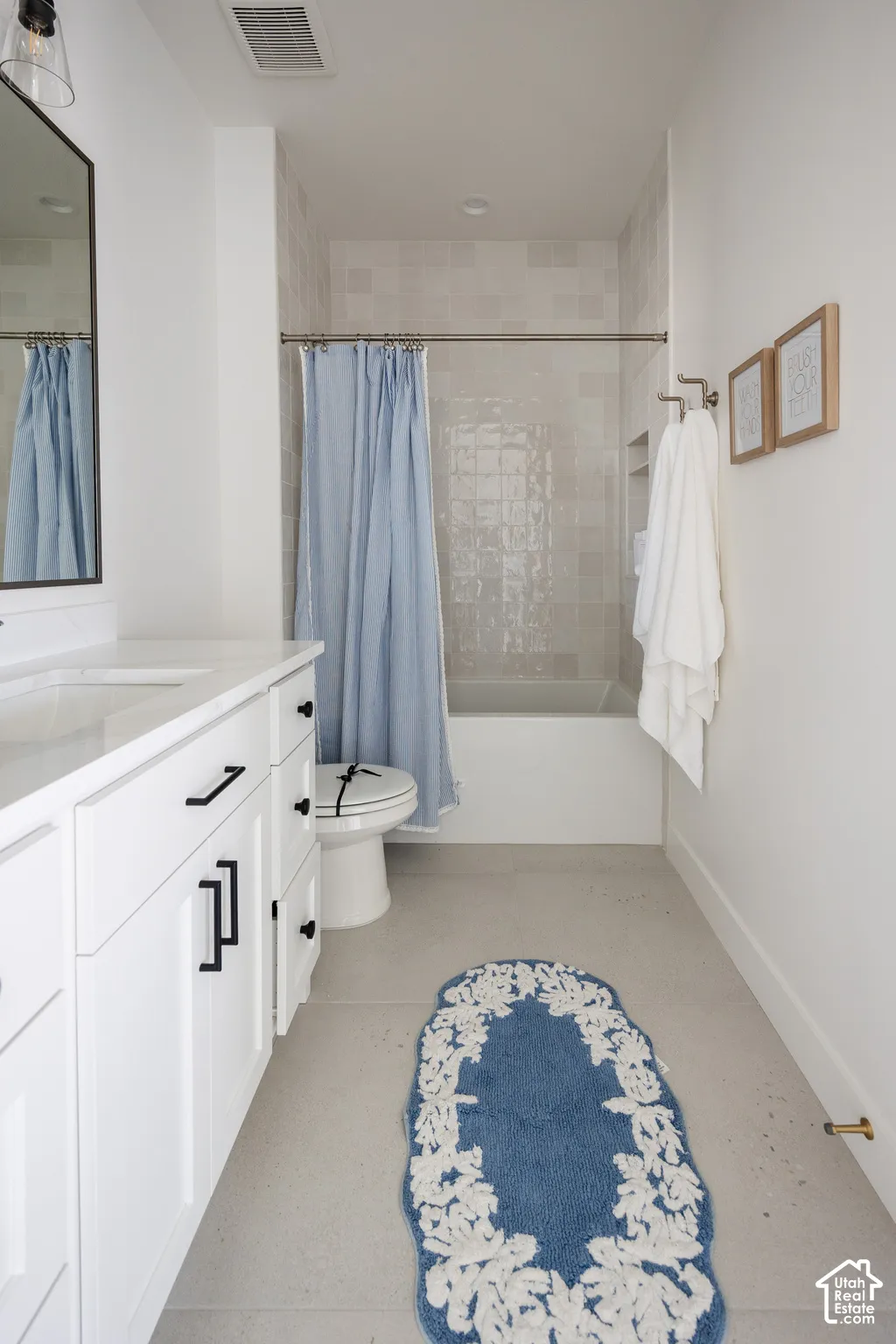 White vanity with black hardware, white countertop, and integrated sink
