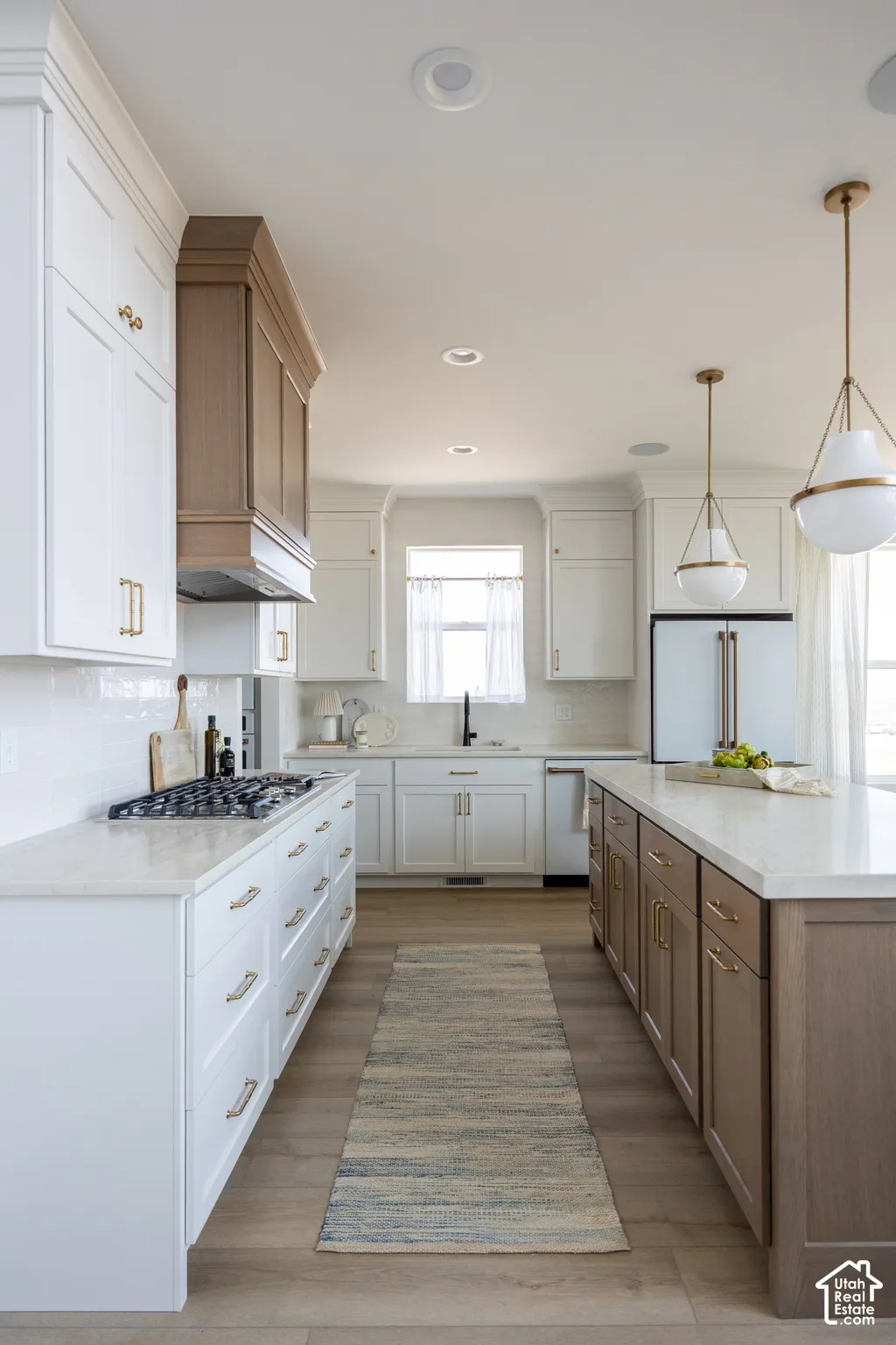 Kitchen featuring white upper cabinetry, wood-finish lower cabinetry, a gas range, white subway tile backsplash, and recessed lighting