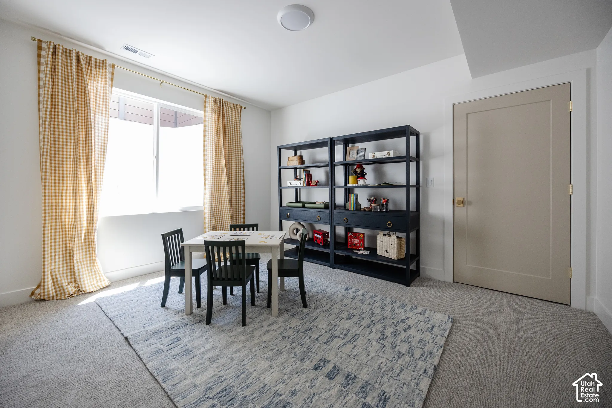 Recessed lighting, light-colored walls, and neutral-toned carpeting throughout