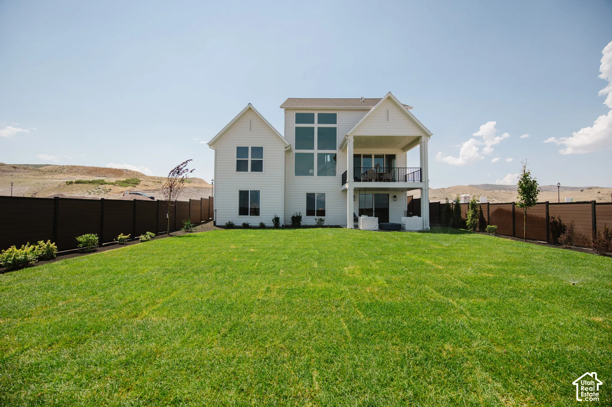 Expansive manicured lawn with a privacy fence