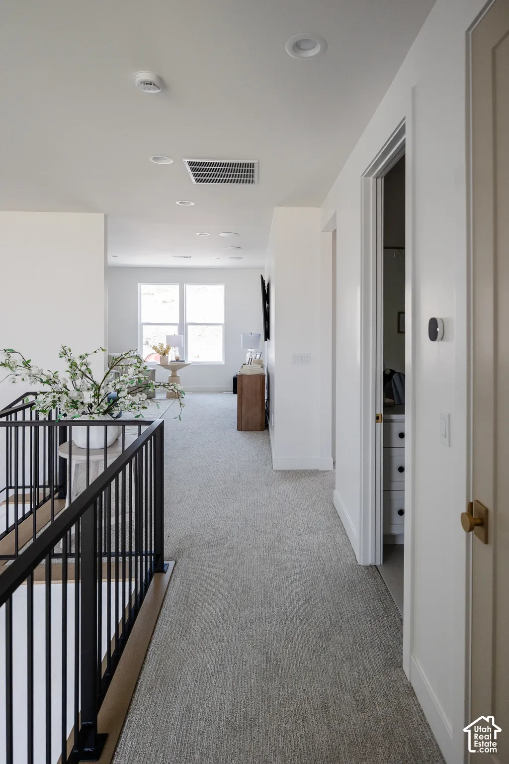 Upper-level hallway with light-toned carpeting and recessed lighting