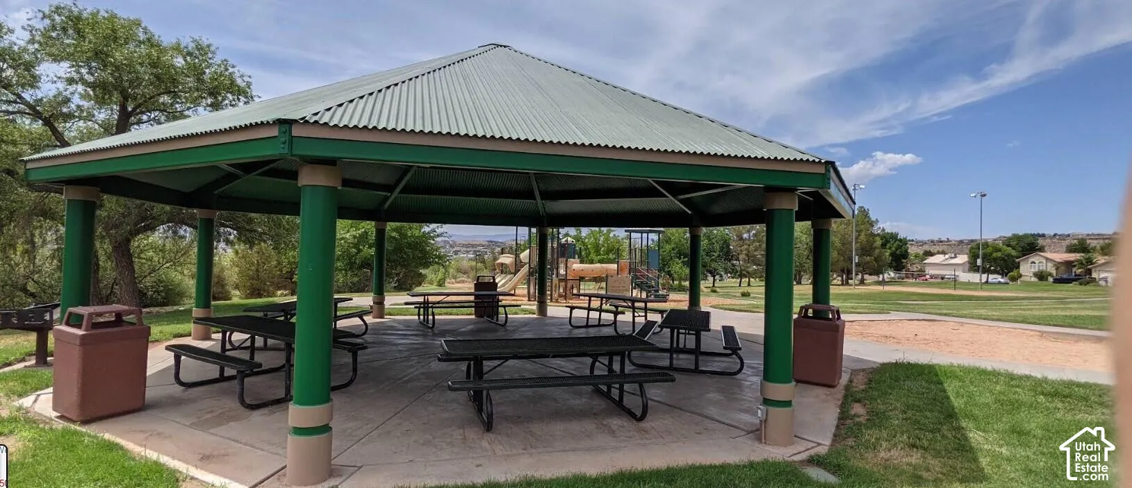 Expansive outdoor pavilion with a corrugated metal roof, supported by robust columns