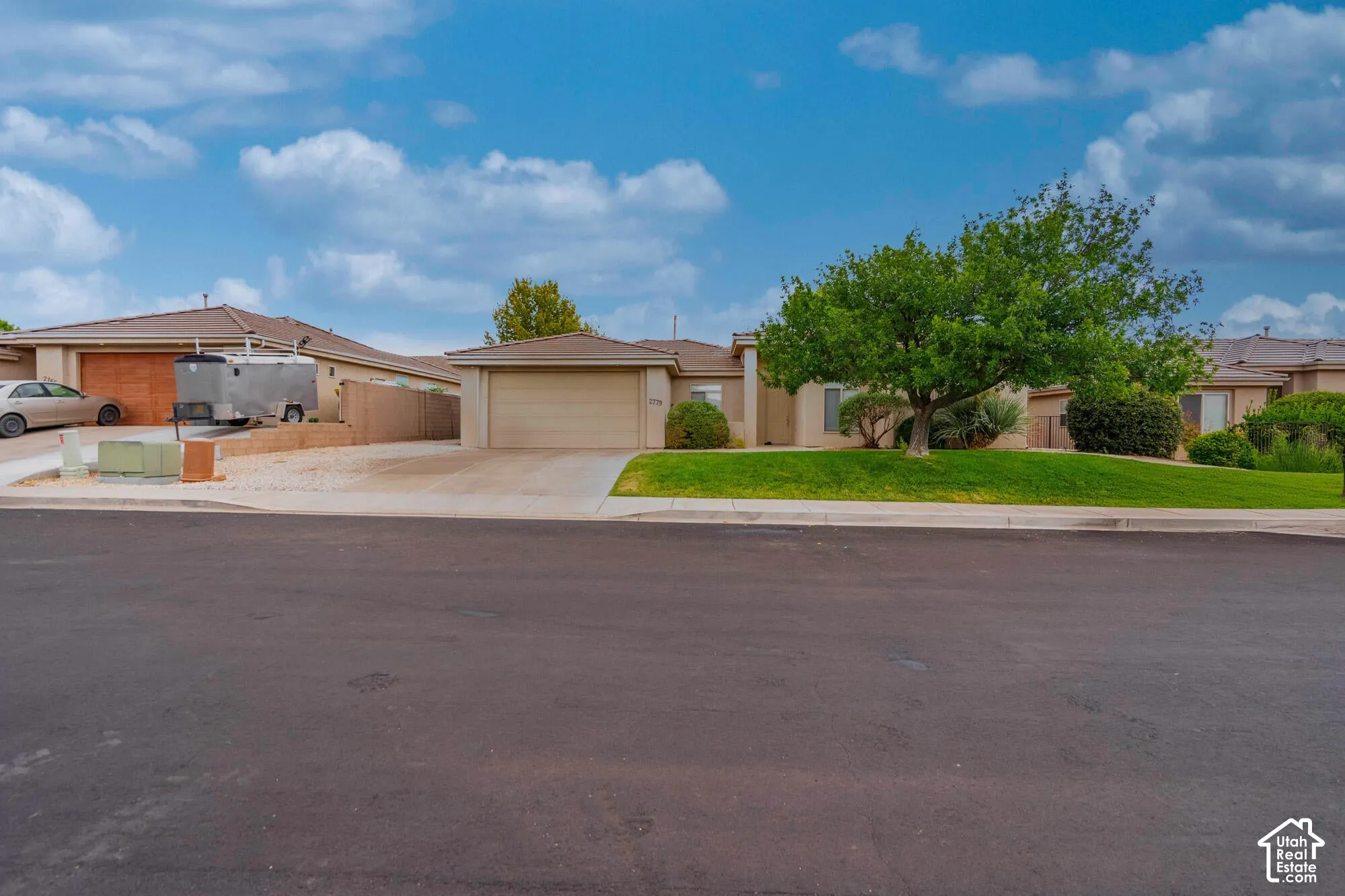 Single-story stucco exterior with an attached garage, a second garage, and a concrete driveway