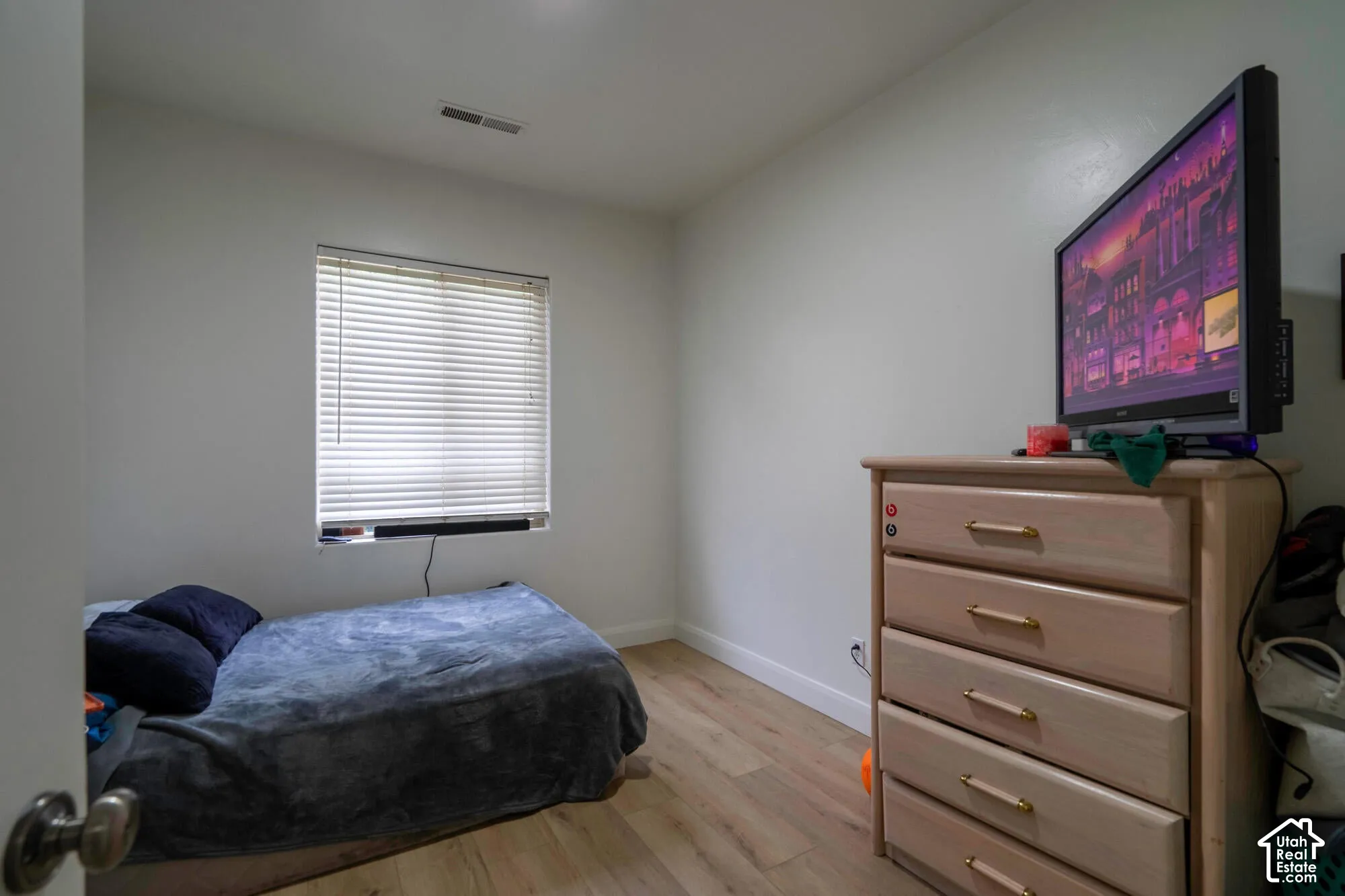Wood-finish flooring with white baseboards, single window with blinds, and recessed ceiling light