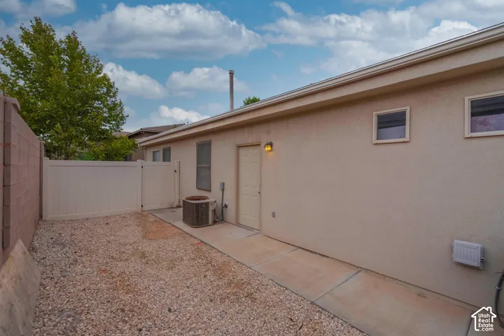Compact side yard featuring gravel landscaping, a concrete pathway, and a privacy fence