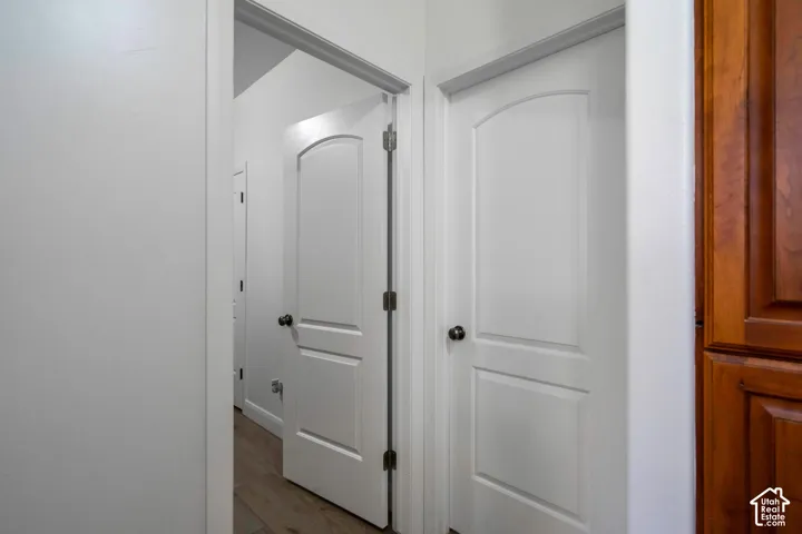 White panel doors with dark hardware, light wood-finish flooring, and light-toned wall paint