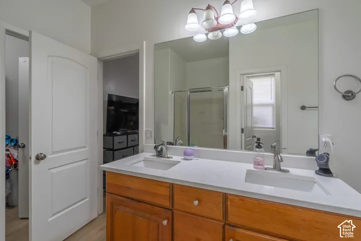 Double vanity with undermount sinks, wood-finish cabinetry, and a large wall-mounted mirror