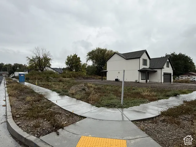 Corner lot featuring a two-story exterior with vertical siding, gabled rooflines, and an attached garage