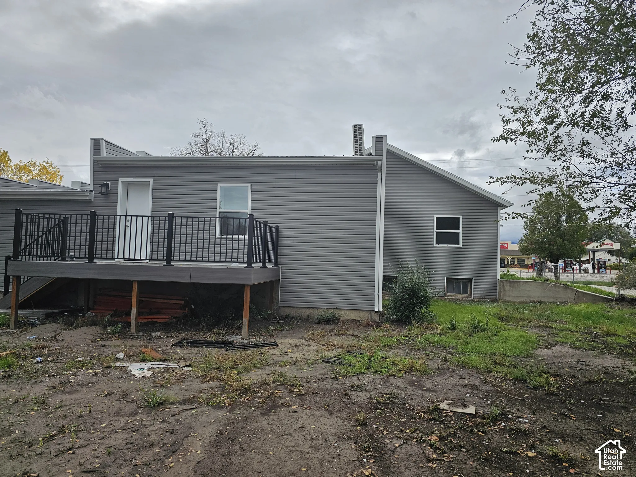 Exterior featuring gray siding, a composite deck with black railings, and multiple windows